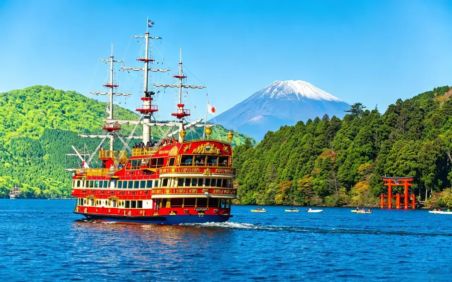 A sightseeing ship crossing Lake Ashi with Mount Fuji in the distance