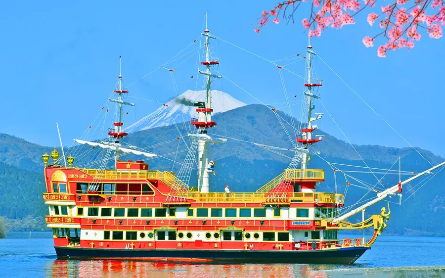A sightseeing ship on Lake Ashi with cherry blossom on the shore